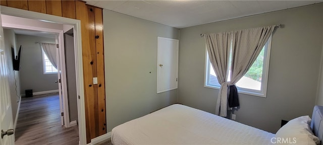 bedroom featuring wood walls and hardwood / wood-style flooring