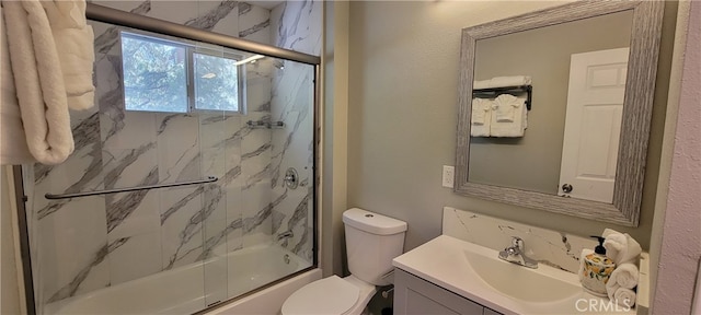 full bathroom featuring toilet, bath / shower combo with glass door, and vanity