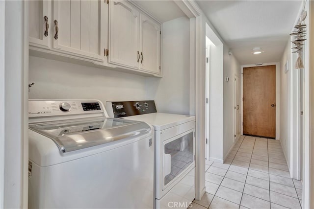 washroom with cabinets, a textured ceiling, light tile patterned flooring, and washer and clothes dryer