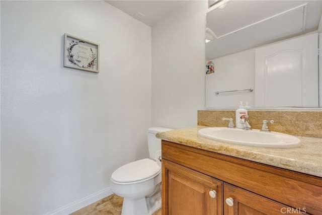 bathroom with tile patterned flooring, vanity, and toilet