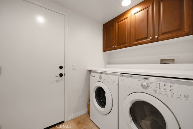 clothes washing area featuring cabinets, light tile patterned floors, and washer and dryer