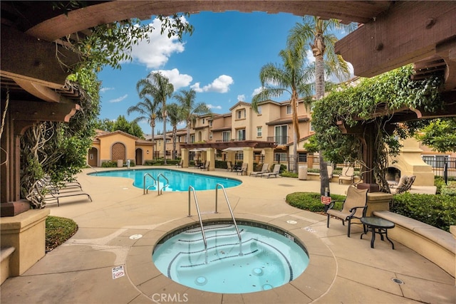 view of swimming pool featuring a community hot tub and a patio area