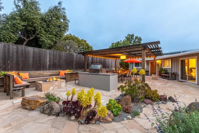 view of patio featuring area for grilling, an outdoor kitchen, a pergola, and an outdoor fire pit