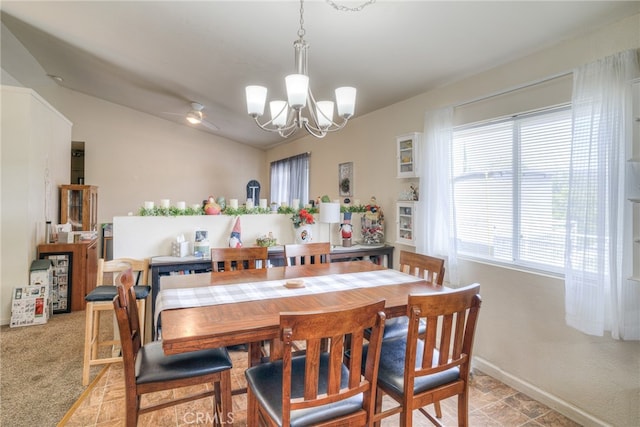 dining area featuring a chandelier, vaulted ceiling, and light colored carpet