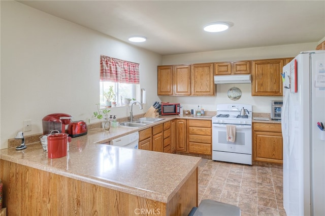 kitchen featuring sink, kitchen peninsula, and white appliances