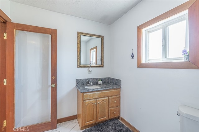 bathroom with vanity, a textured ceiling, and toilet