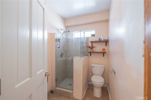 bathroom featuring tile patterned floors, a shower with shower door, and toilet