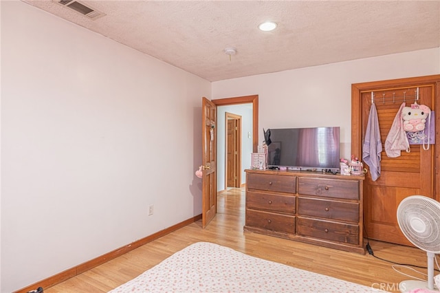 bedroom featuring a textured ceiling and light wood-type flooring