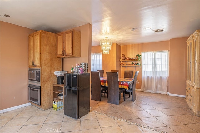 kitchen featuring a notable chandelier, decorative light fixtures, stainless steel appliances, and light tile patterned floors