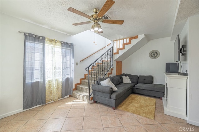 living room with a textured ceiling, light tile patterned floors, and ceiling fan