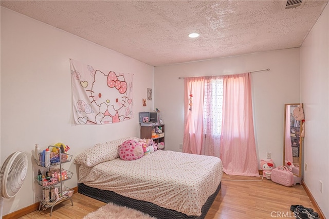 bedroom featuring a textured ceiling and light wood-type flooring