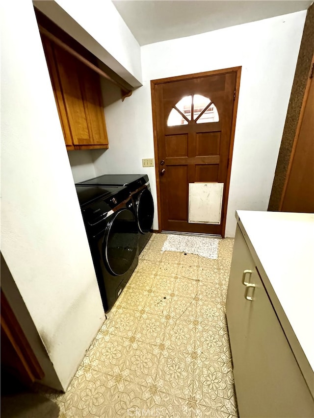 clothes washing area with cabinets and separate washer and dryer