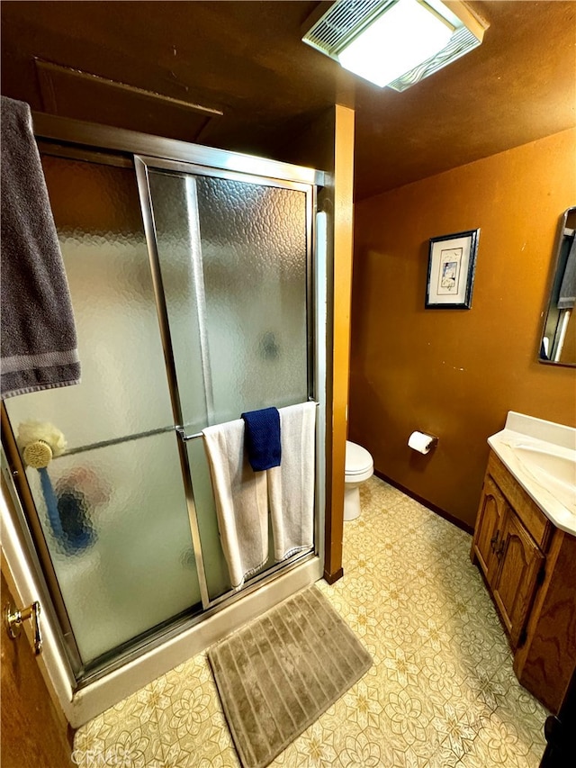 bathroom with toilet, walk in shower, vanity, and tile patterned floors