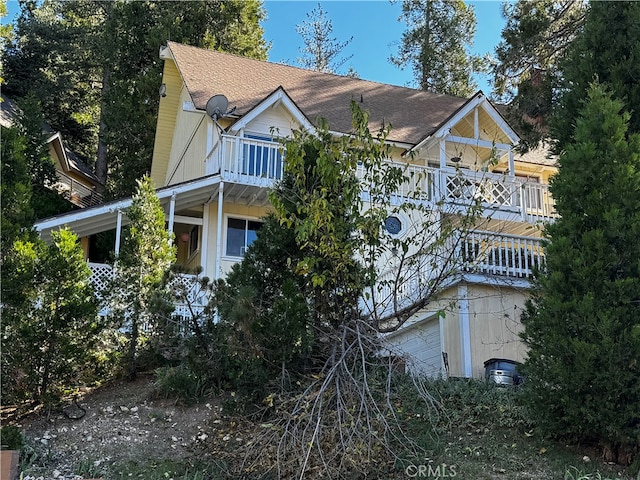 view of side of property featuring a balcony and a garage