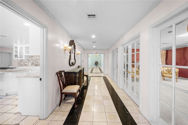 hallway featuring light tile patterned floors and crown molding