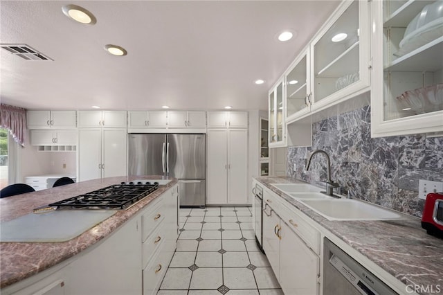 kitchen featuring backsplash, sink, white cabinetry, and stainless steel appliances