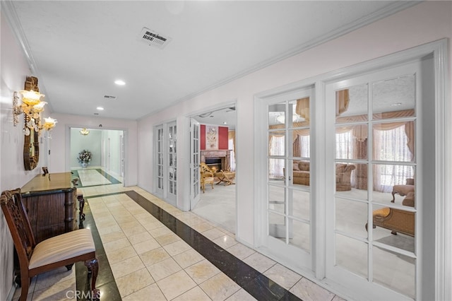 entryway with french doors, light tile patterned flooring, and ornamental molding