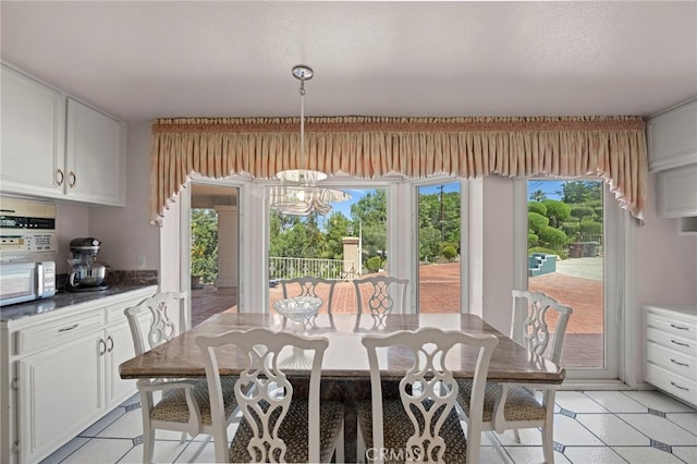 tiled dining area featuring an inviting chandelier