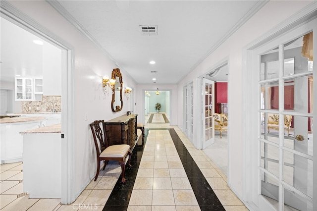 hall with light tile patterned floors and ornamental molding