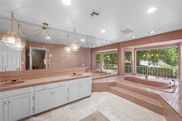 bathroom featuring tiled bath and vanity