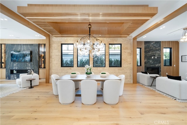 dining space featuring a fireplace, plenty of natural light, and light hardwood / wood-style flooring