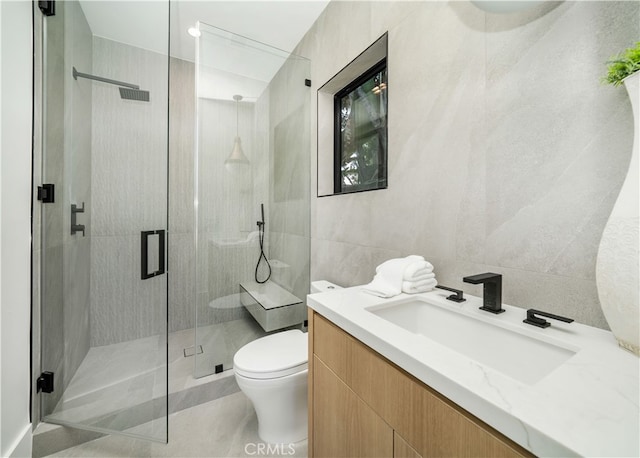 bathroom featuring walk in shower, tile walls, toilet, and vanity