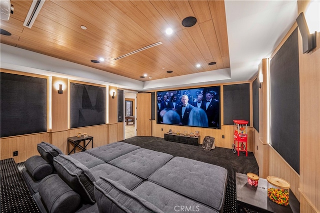 home theater room with a tray ceiling and wood ceiling