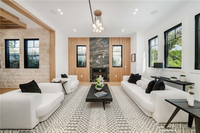 living room with wood walls, a large fireplace, and hardwood / wood-style flooring