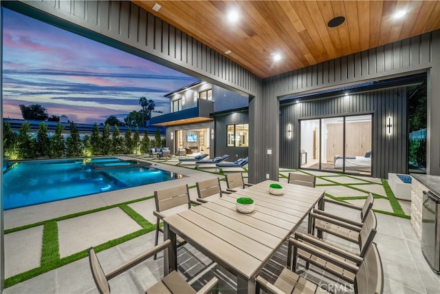 pool at dusk featuring a patio area