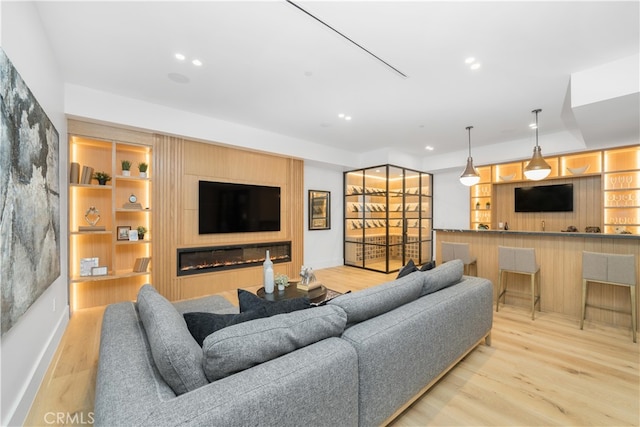 living room with light hardwood / wood-style floors and built in shelves