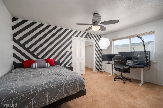 carpeted bedroom with ceiling fan and a textured ceiling