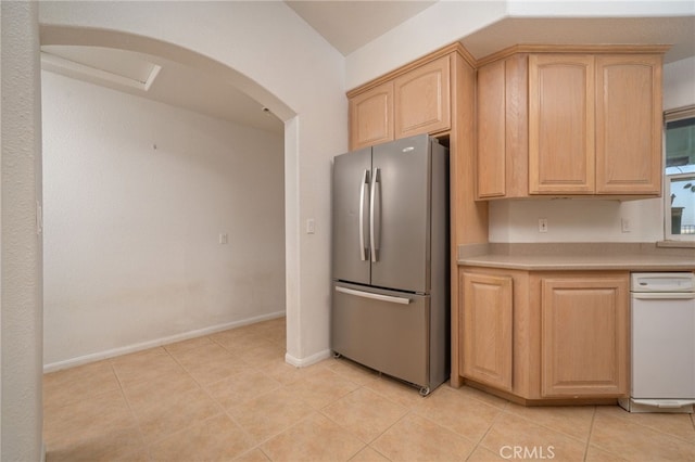 kitchen with stainless steel refrigerator, light brown cabinets, and light tile patterned floors