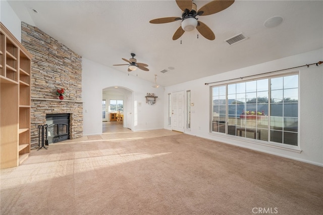 unfurnished living room with a fireplace, light colored carpet, a wealth of natural light, and ceiling fan