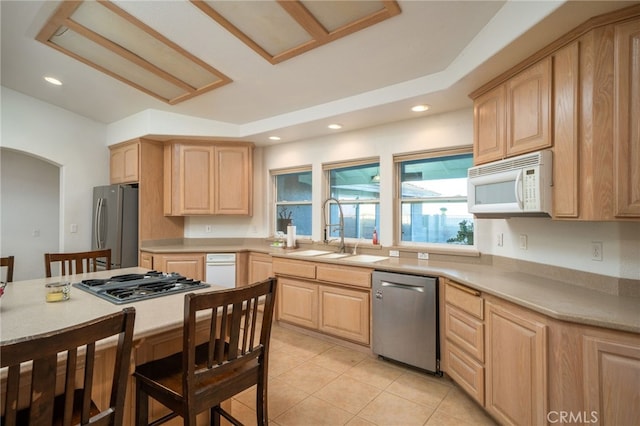 kitchen featuring appliances with stainless steel finishes, light brown cabinets, and sink