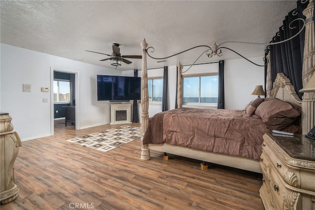 bedroom featuring hardwood / wood-style floors, a textured ceiling, and multiple windows