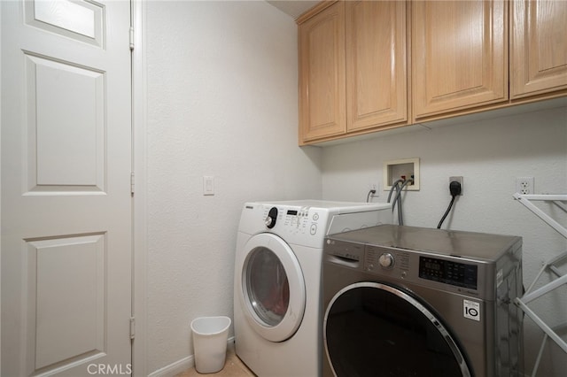 washroom featuring cabinets and washing machine and clothes dryer