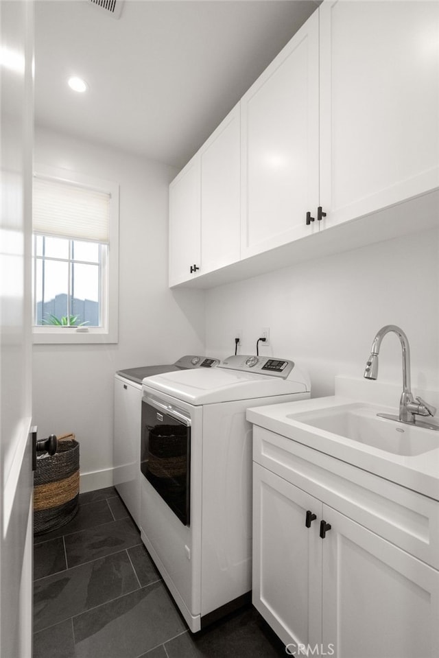 washroom featuring cabinets, washer and dryer, sink, and dark tile patterned floors