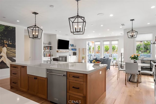 kitchen with dishwasher, a healthy amount of sunlight, decorative light fixtures, and light wood-type flooring