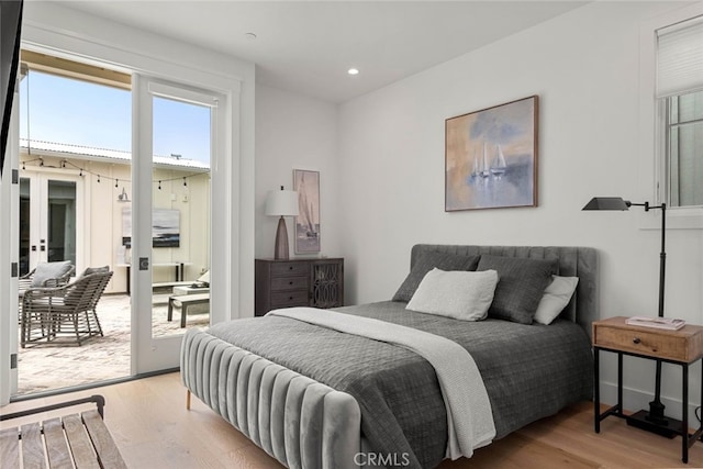 bedroom featuring french doors, light hardwood / wood-style flooring, and access to exterior