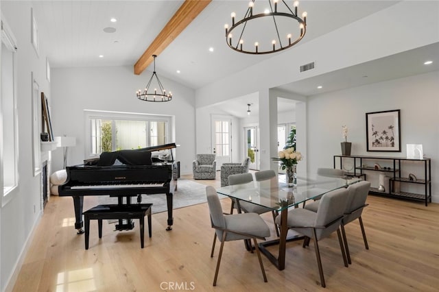 dining area featuring beam ceiling, light wood-type flooring, and plenty of natural light