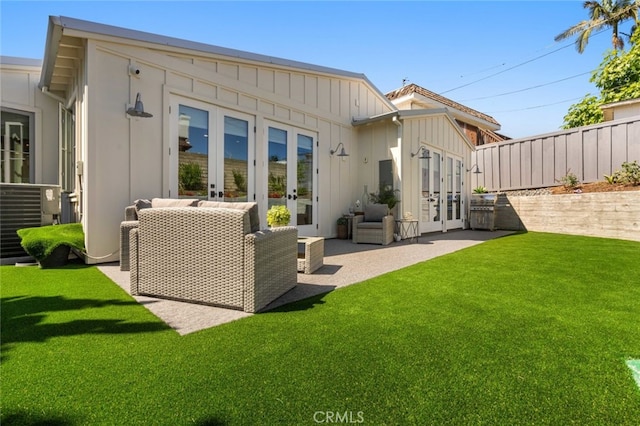 rear view of house featuring french doors, a patio, and a lawn