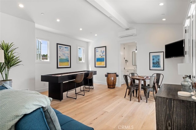 living room with light hardwood / wood-style floors, a wall mounted AC, and vaulted ceiling with beams