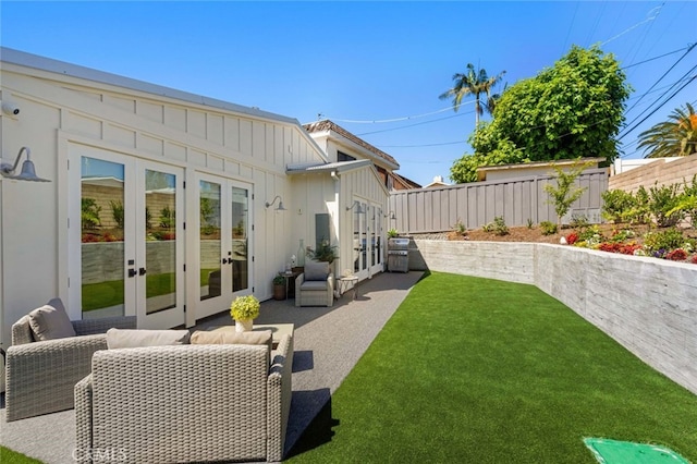 back of house with french doors, a patio area, and a lawn