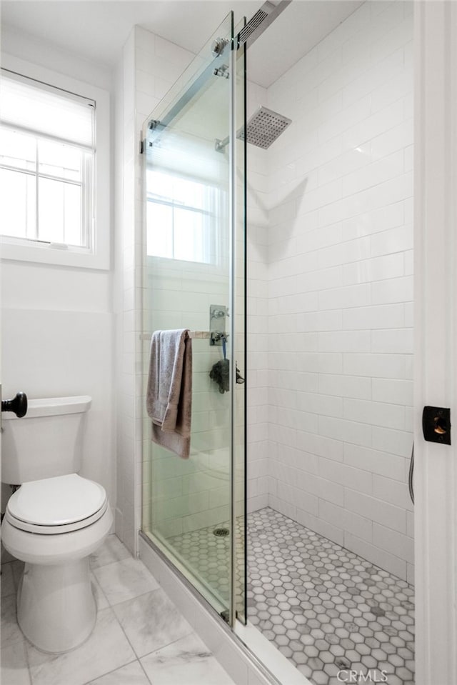 bathroom featuring toilet and an enclosed shower