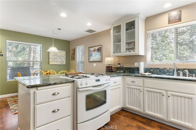kitchen featuring white range with gas stovetop, sink, white cabinetry, and dark wood-type flooring