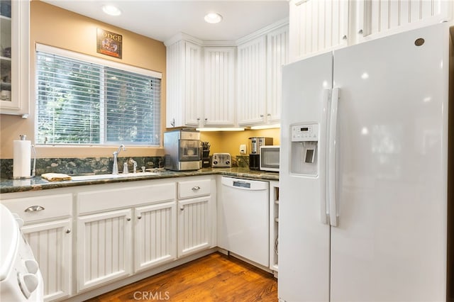 kitchen featuring white cabinets, wood-type flooring, white appliances, and dark stone countertops