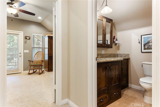 bathroom with toilet, ceiling fan, tile patterned floors, vaulted ceiling, and vanity