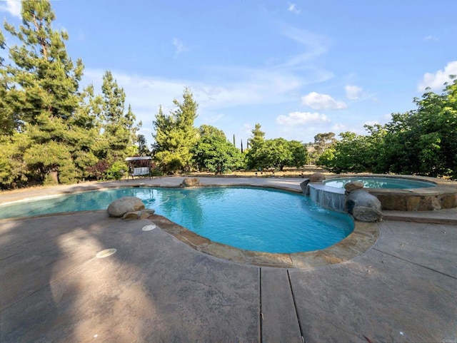 view of swimming pool with a patio and a pool with connected hot tub