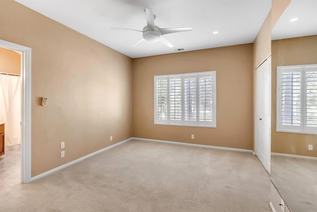 unfurnished bedroom with baseboards, light colored carpet, and multiple windows