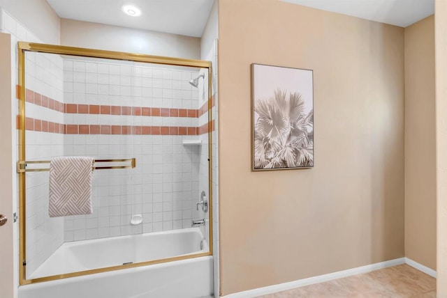 bathroom featuring baseboards, bath / shower combo with glass door, and tile patterned flooring